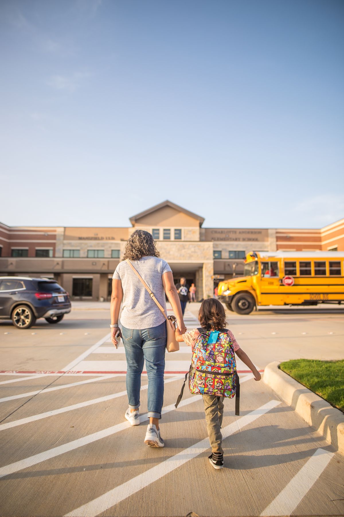 Mãe acompanhando a filha a caminho da escola